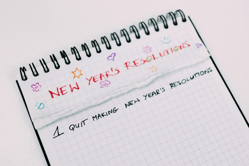 A notebook page with handwritten New Year's resolutions in colorful text.